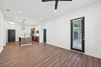 A spacious room with wooden floors and a ceiling fan.